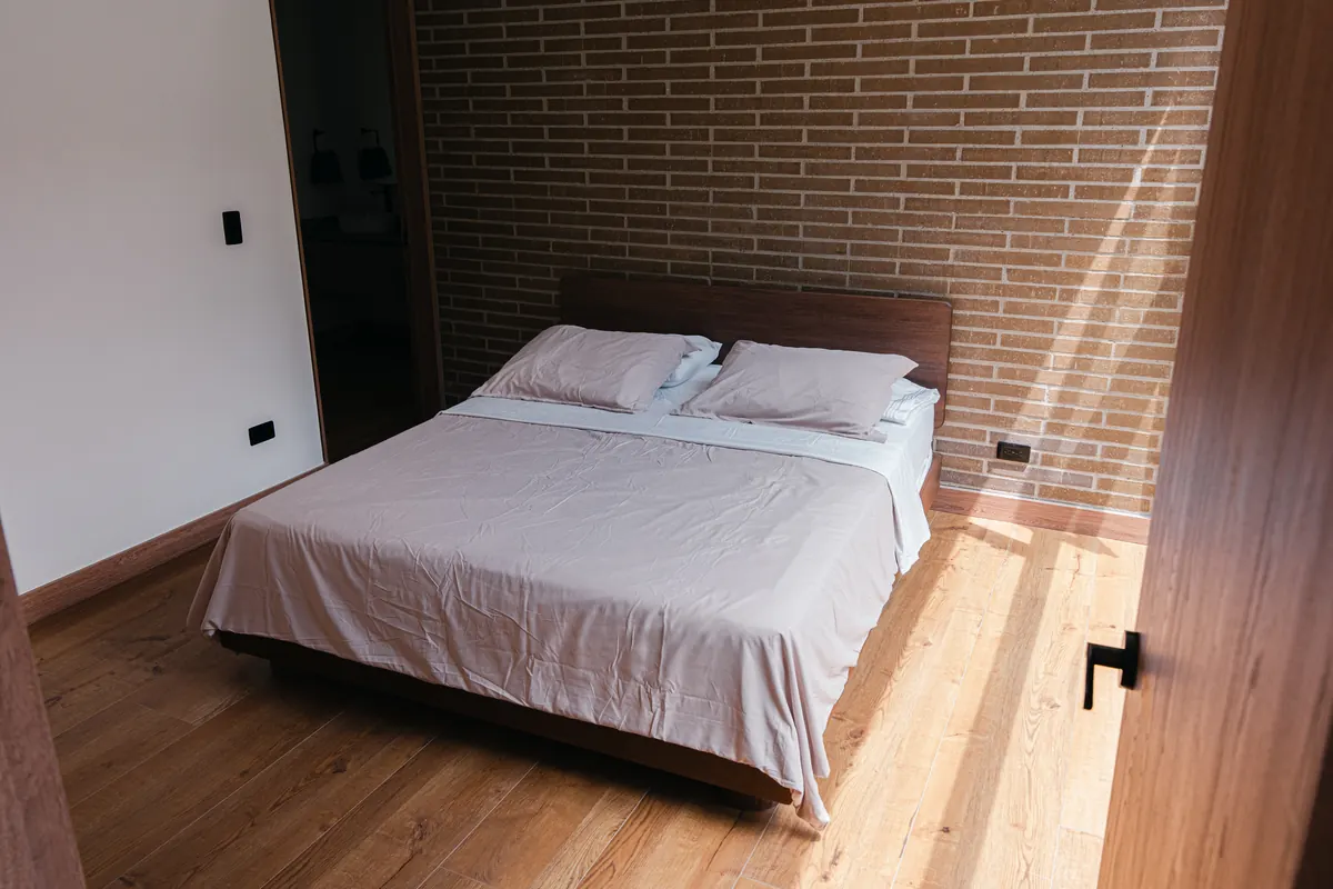 Bedroom with a Queen bed and a brick wall