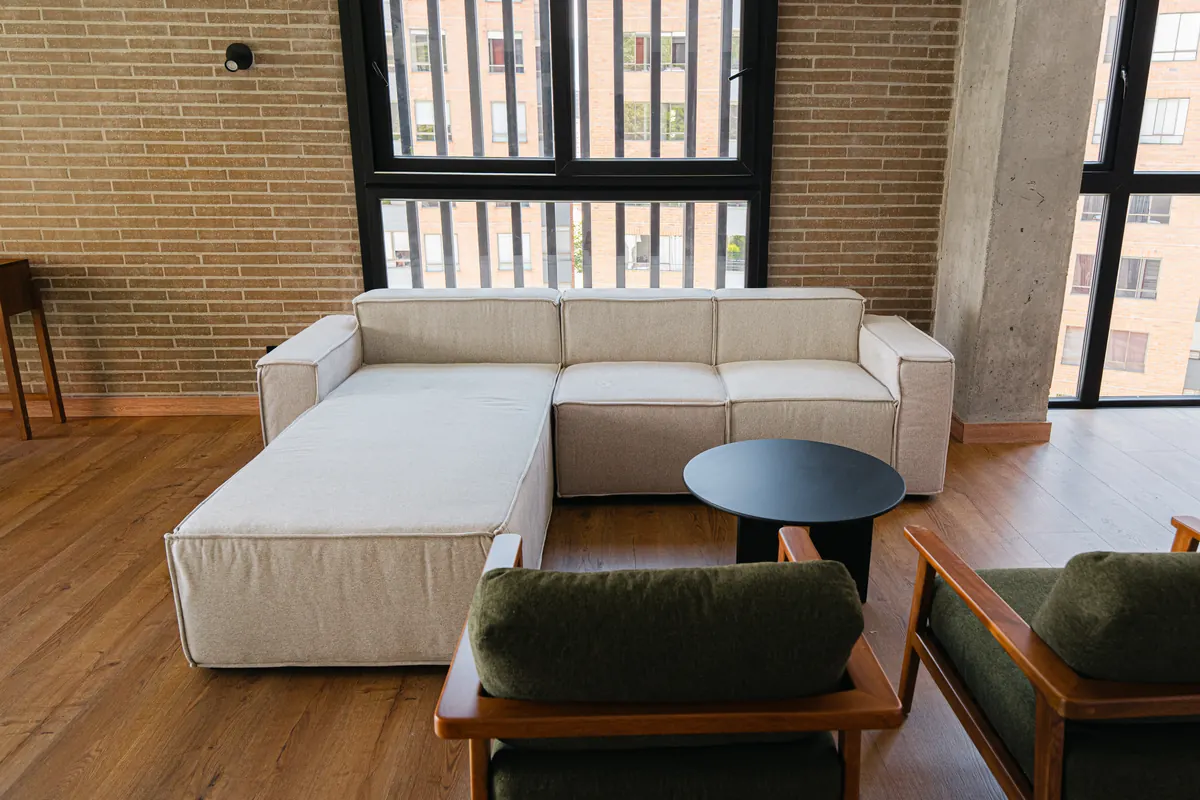 Penthouse living room with double-height windows and a brick wall