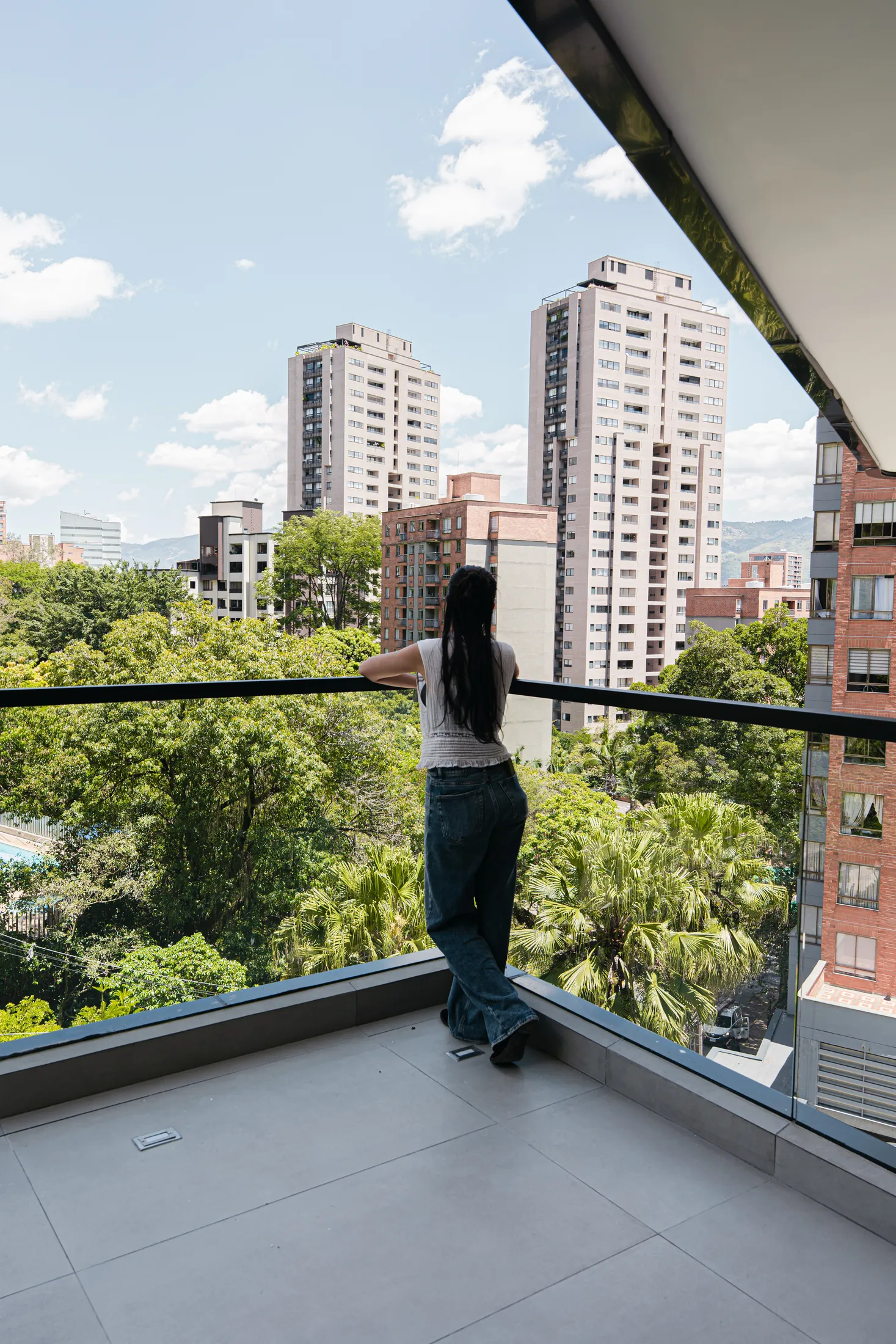 Altitud's terrace overlooking the treetops and buildings of Castropol, Medellín